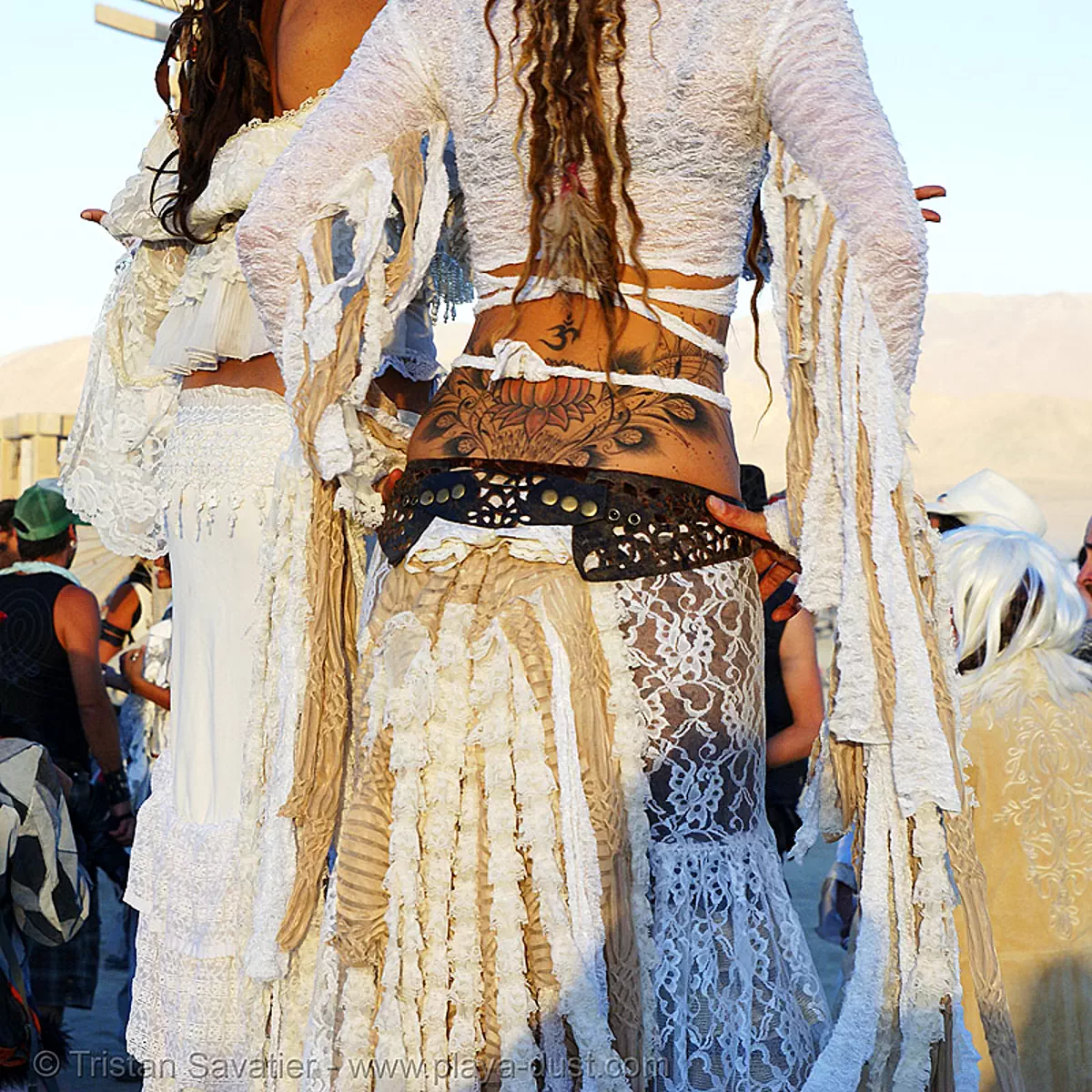 natalia and pema at the silent white procession - burning man 2007, burning man festival, dawn, feathers, lotus flower tattoo, stilts, stiltwalker, stiltwalking, sun rise, tattooed, white morning, stock photo