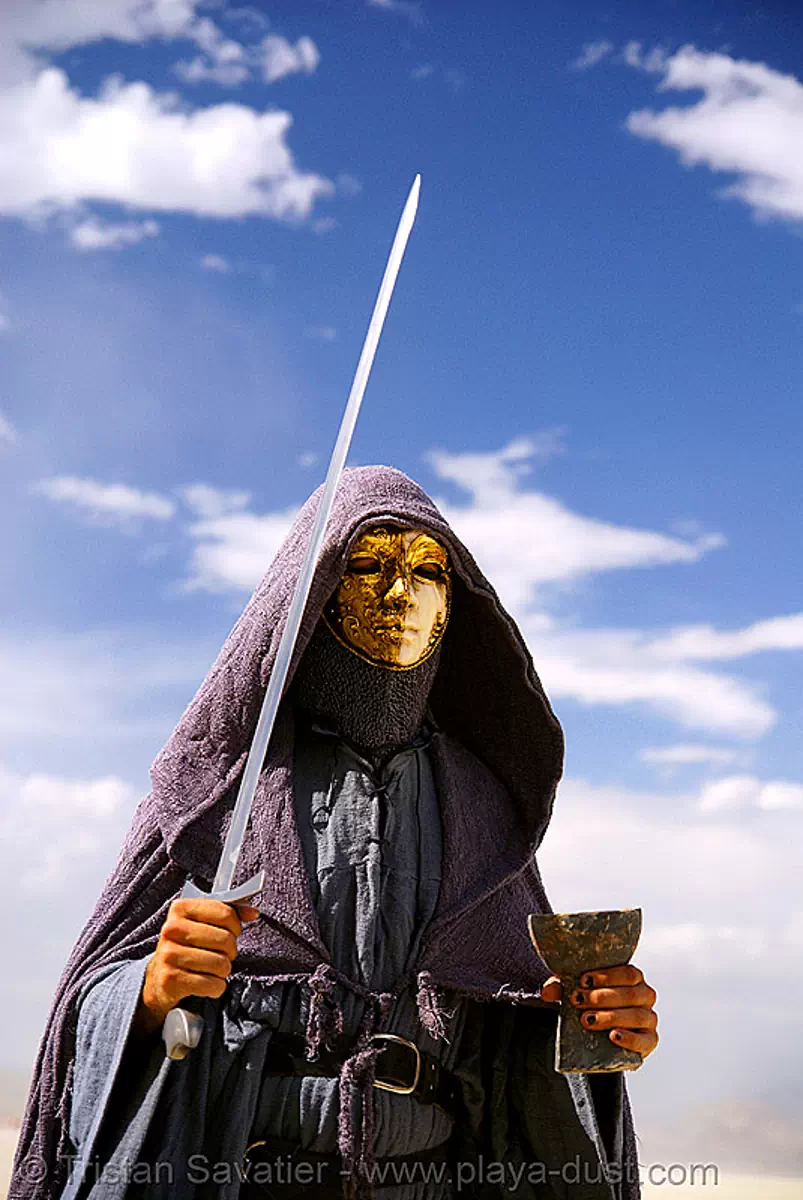 knight with sword and golden mask walking around the temple - burning man 2007, burning man festival, chalice, golden color, hood, stock photo