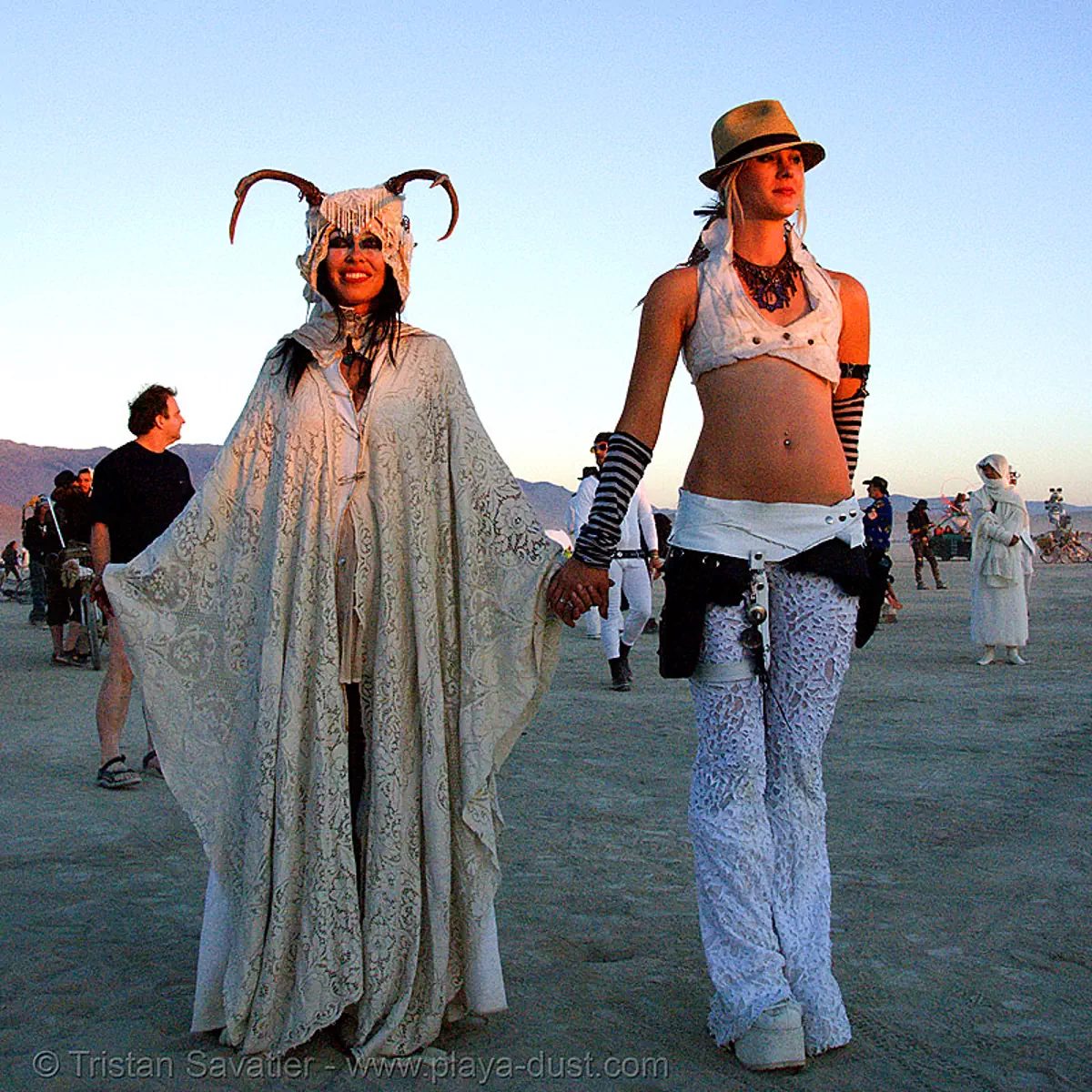 stardust at the silent white procession at dawn - burning man 2007, burning man festival, fedora hat, gangster hat, horns, sun rise, white morning, stock photo