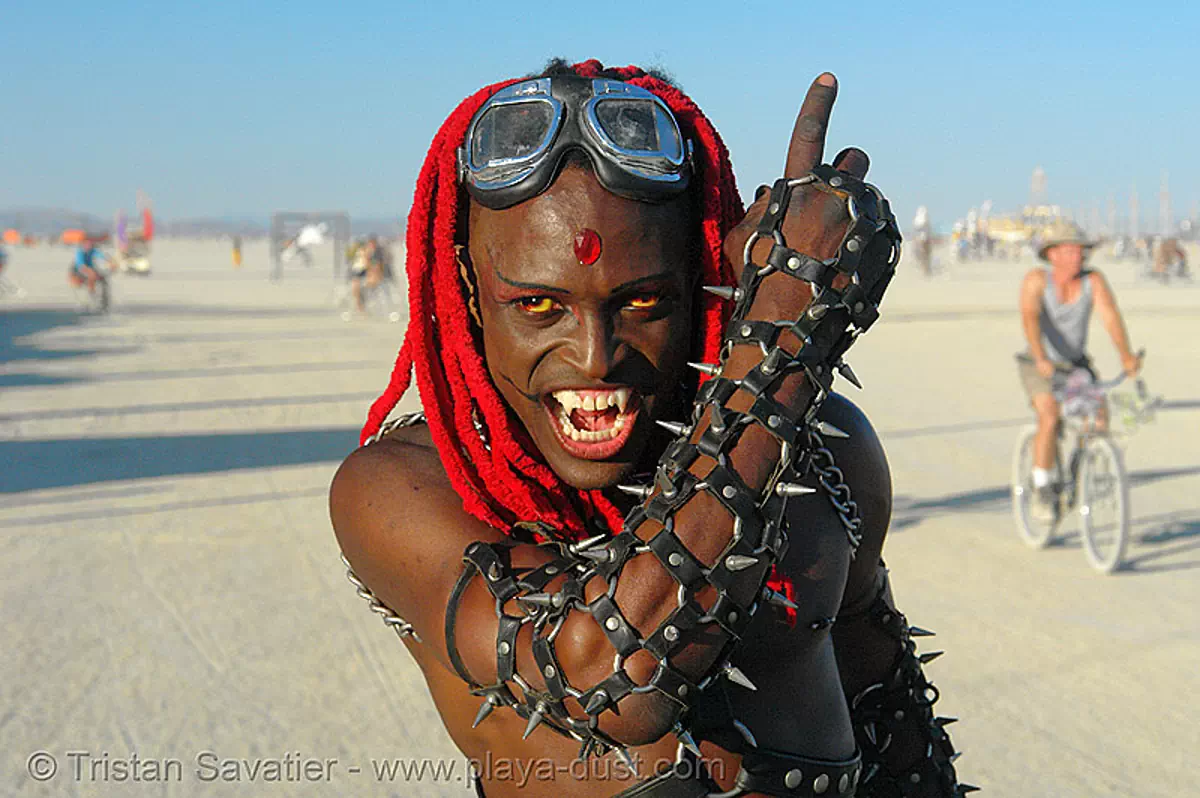 vampire, african american man, arm, bicolor contact lenses, bindis, burning man festival, color contact lenses, contacts, damon knight, dreadlocks, goggles, leather, red hair, special effects contact lenses, spikes, theatrical contact lenses, vampire fangs, stock photo