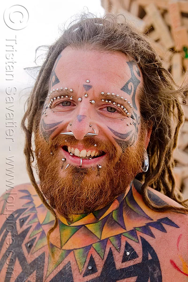 eyebrow piercing - face piercings, andrew, barbells, bridge piercing, burning man festival, face tattoo, gauged ears, lip piercing, tattooed, stock photo
