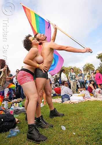 couple dancing with rainbow flag, dancing, flag pole, gay pride festival, man, rainbow flag, topless, woman