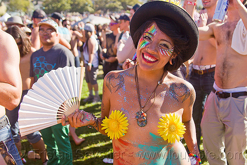 sunfower girl with face paint, hat and fan, black hat, face painting, facepaint, fan, gay pride festival, glitter, heart tattoos, josie, necklace, rainbow makeup, shoulder tattoos, sunflower pasties, sunflowers, winged hearts tattoos, woman, yellow flowers
