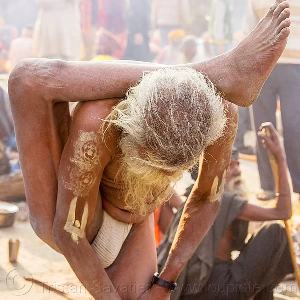 Yogi sadhu in yoga position standing with leg behind the 