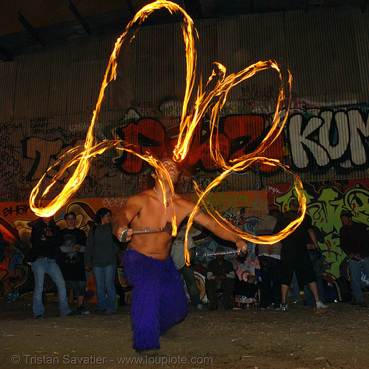 john-paul spinning fire poi (san francisco), fire dancer, fire dancing, fire performer, fire spinning, flame, graffiti, industrial, long exposure, night, toxic beach, warehouse, stock photo