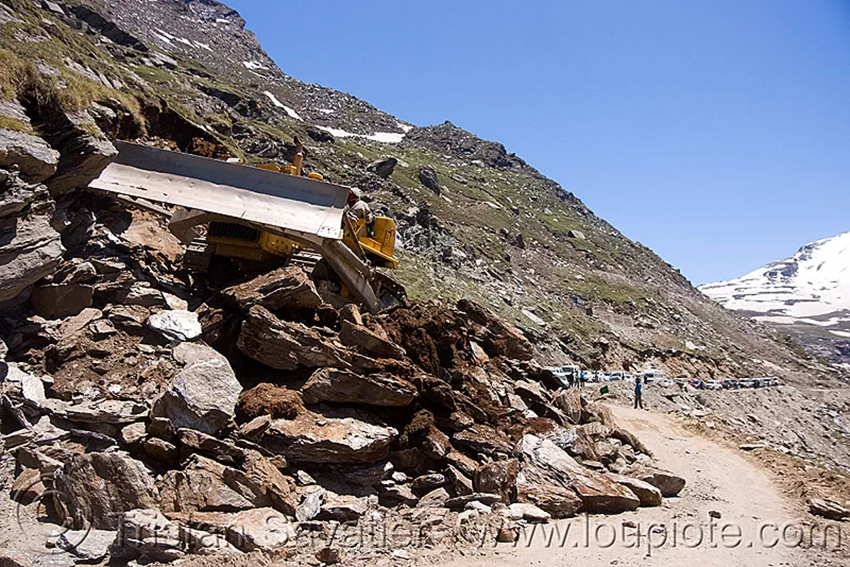 bulldozer clearing rocks on mountain road - manali to leh road (india), bd80, beml, dozer, groundworks, heavy equipment, hydraulic, machinery, road construction, roadworks, rohtang pass, rohtangla, rubble, stock photo