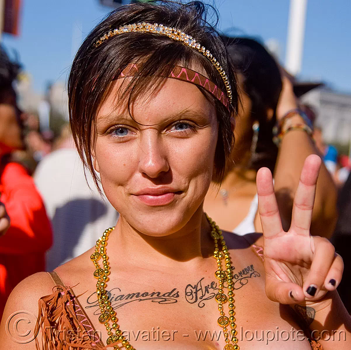 woman with "diamonds are forever" chest tattoo, festival, love fest, lovevolution, peace sign, tattooed, v-sign, stock photo