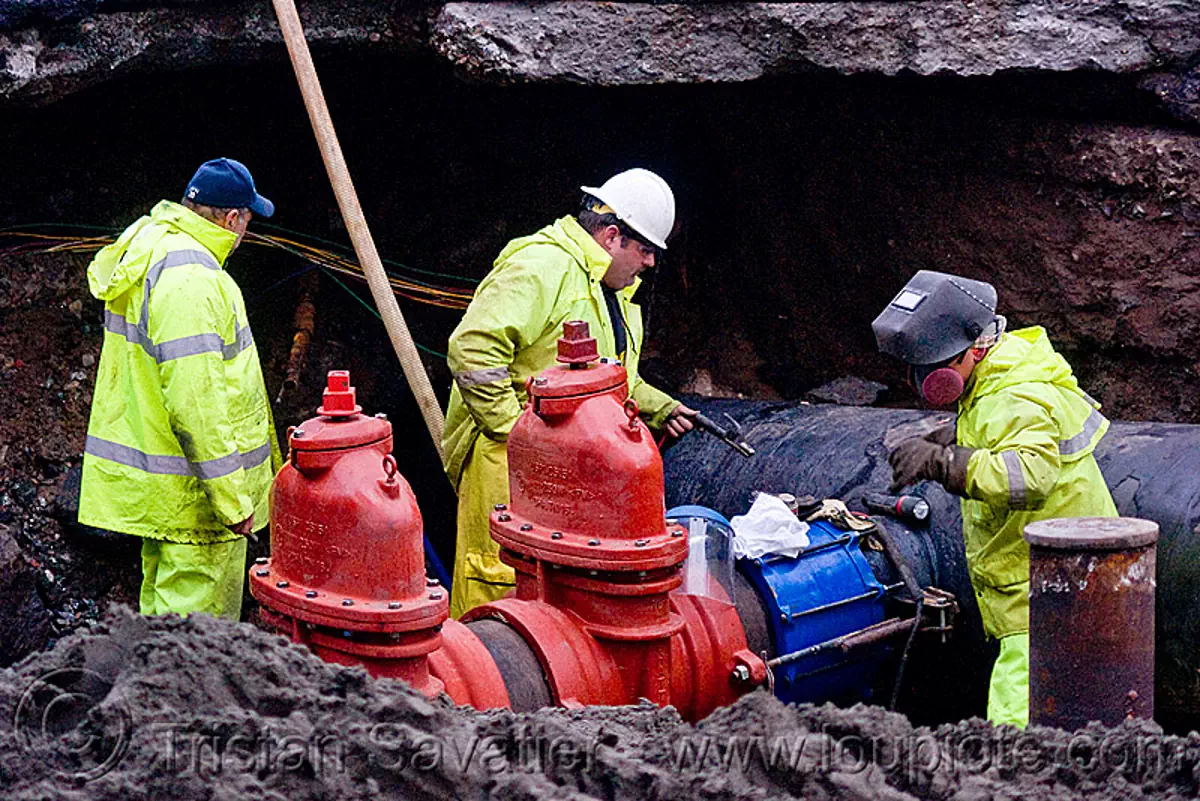 C515 cut-off valves - utility workers fixing broken water main (san francisco), awwa c515, construction workers, dust mask, gate valves, hetch hetchy water system, infrastructure, reflector vest, repairing, resilient, respirator, safety helmet, safety vest, sfpuc, sink hole, utility crew, water department, water pipe, stock photo