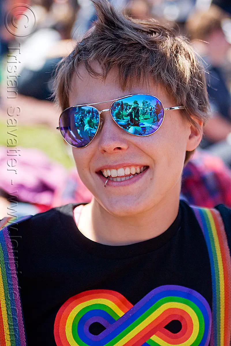 woman with blue mirror sunglasses, blue sunglasses, dolores park, gay pride festival, infinity sign, infinity symbol, jess, lip piercing, mohawk hair, pugs sunglasses, rainbow colors, rainbow tshirt, stock photo