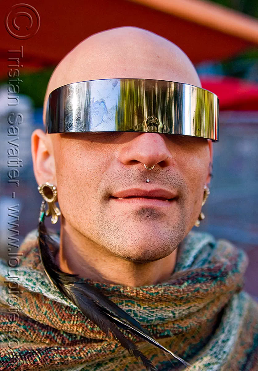 man with visor sunglasses, bald, feather earring, gay pride festival, shaved head