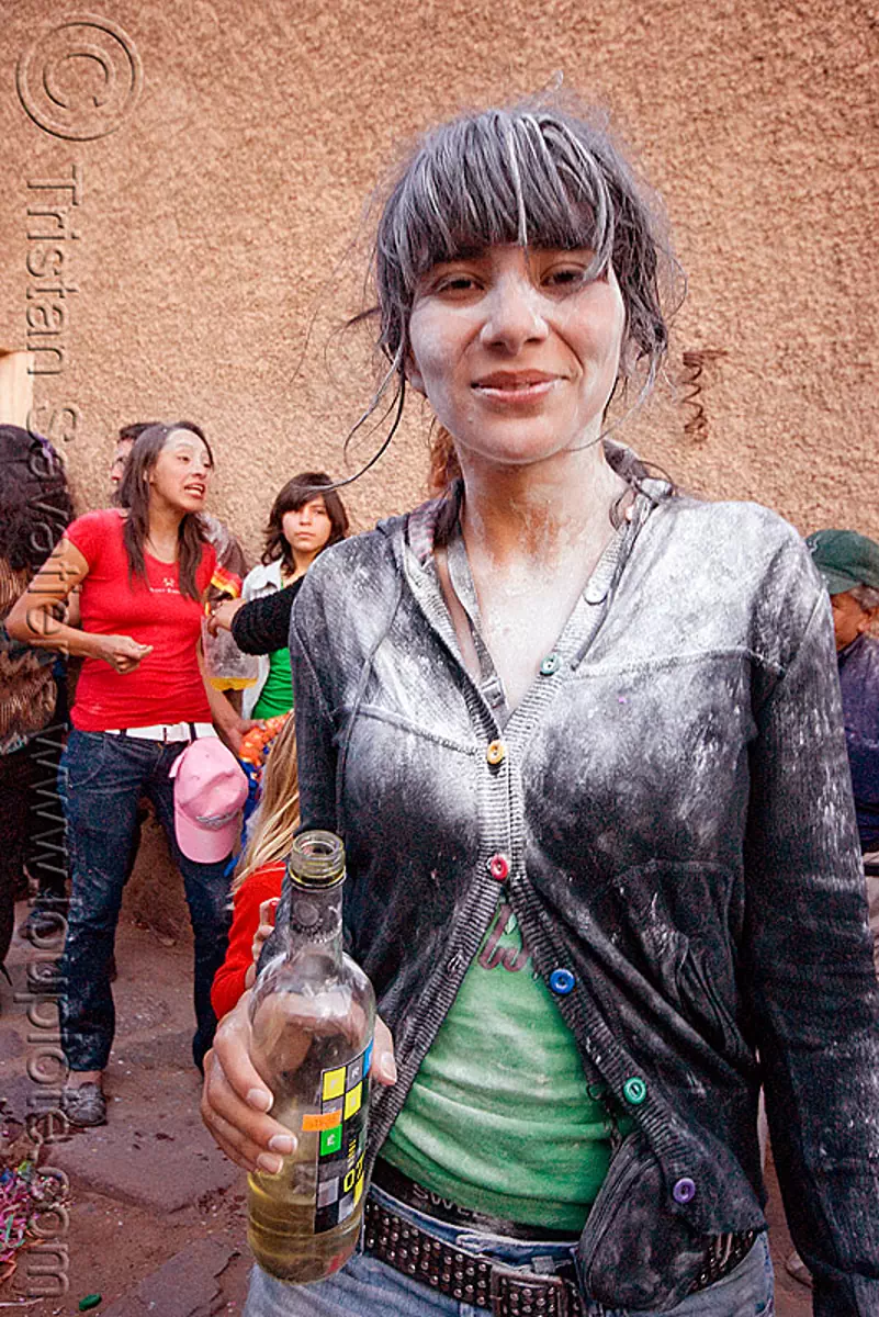 white girl with bottle of white wine - carnaval de humahuaca (argentina), carnival, noroeste argentino, quebrada de humahuaca, talk powder, stock photo