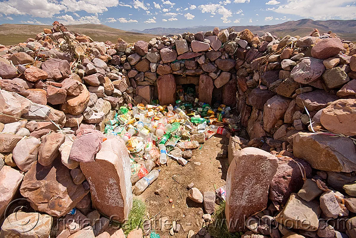 pollution - plastic bottles trash in ancient apacheta (argentina), environment, garbage, iruya, monument, noroeste argentino, quebrada de humahuaca, rubbish, shrine, stone, stock photo