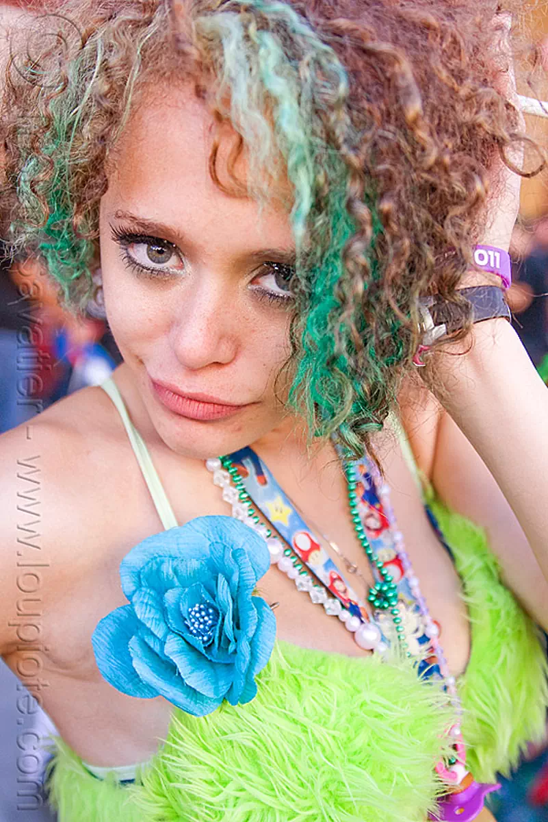 raver girl with green hair and green fuzzy bra, blue flower, gay pride festival, green eyes, kathleen, stock photo