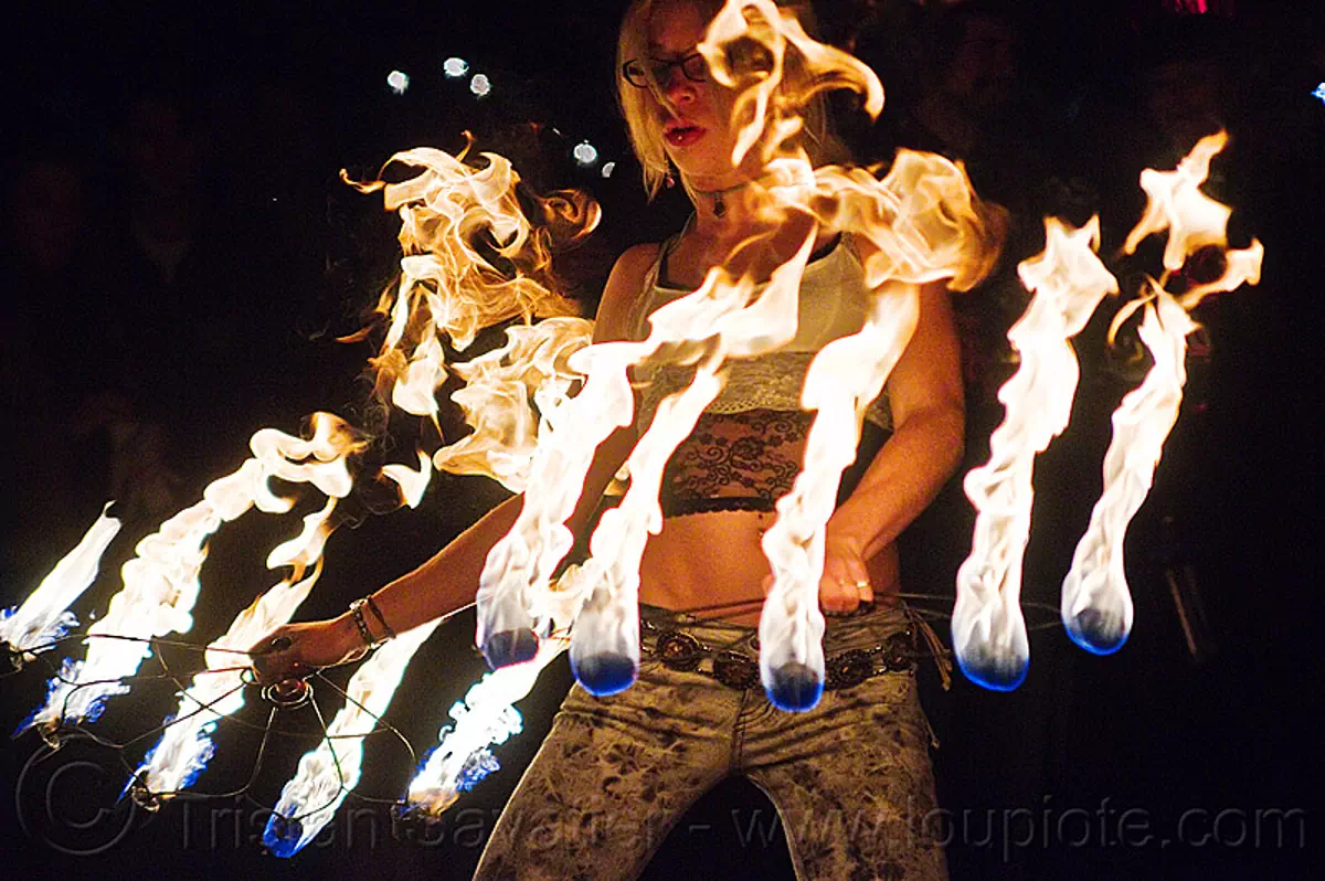 fire dancer with fire fans, american steel studios, cressie mae, fire dancing, fire performer, fire spinning, flame, holidays in flux, night, oakland, poplar gallery, spinning fire, stock photo