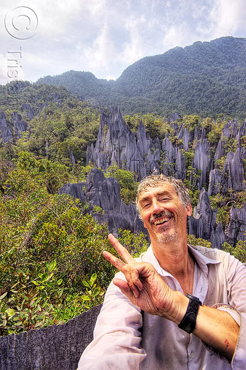 happy to have reached the mulu pinnacles (borneo), erosion, geology, gunung mulu national park, jungle, karst, karstic, limestone, man, peace sign, rain forest, rock, self-portrait, stone, tristan savatier, v-sign, stock photo
