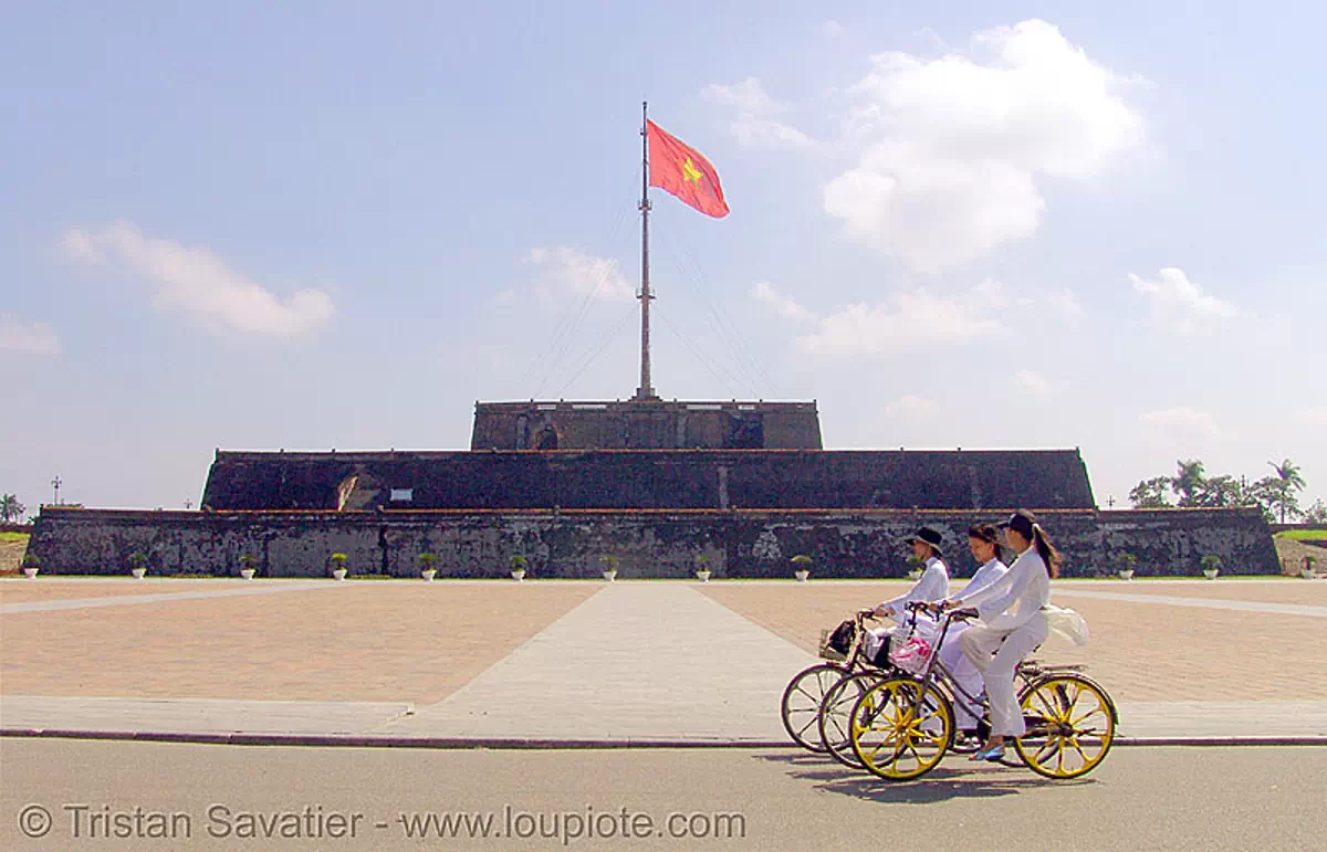 girls on bicycles - cot co flag tower (hu&eacute;) - vietnam, bikes, flagpole, hu&eacute;, red flag, three, vietnam flag