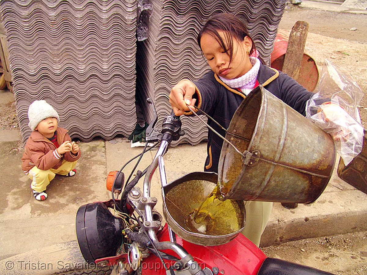 girl fills-up my motorcycle - Мотоциклы Минск 125 - soviet-made minsk 125cc motorcycle - vietnam, bucket, fuel, gas station, gasoline, minsk motorcycle, motorbike, oil, petrol station, quản bạ, red, road, tam son, t&aacute;m sơn, минск 125, мотоциклы, stock photo