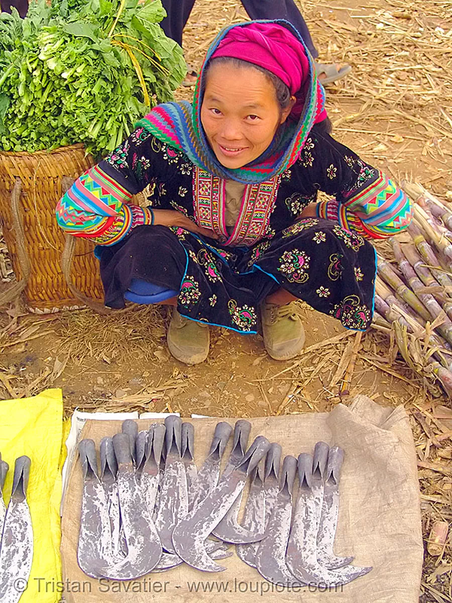 tribe woman selling billhooks at the market - vietnam, asian woman, flower h'mong tribe, flower hmong, hill tribes, m&egrave;o vạc, sickle, stock photo