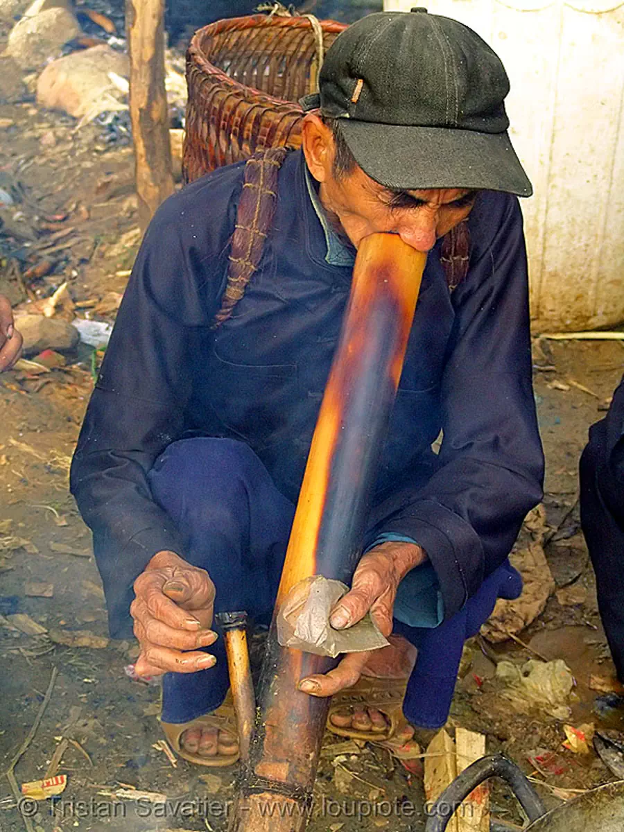 tribe man smoking tobacco with a bamboo pipe - bong - vietnam, hill tribes, market, m&egrave;o vạc, smoke, stock photo
