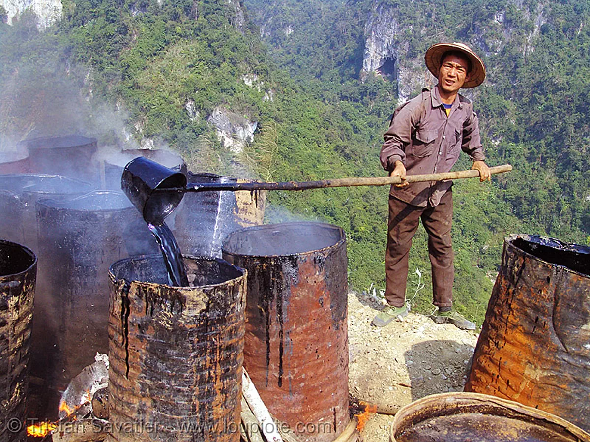 melting barrels of asphalt (bitumen) - vietnam, burning, groundworks, hot asphalt, hot bitumen, macadam, pavement, paving, petroleum, road construction, roadworks, smoke, smoking, worker, stock photo