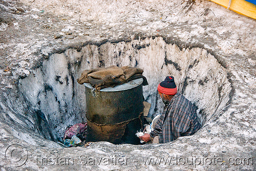 man heating water in a barrel - amarnath yatra (pilgrimage) - indian-administered kashmir