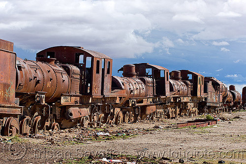 The junkyard has dozens of old steam locomotives and many wrecked train cars
