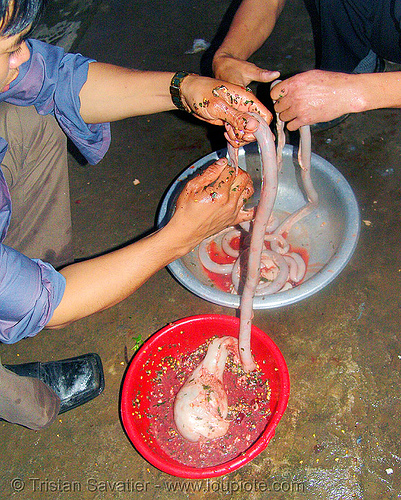 dog meat - stuffing the intestine to make sausages. or should we say, "hot dogs" - thịt ch&oacute; - vietnam