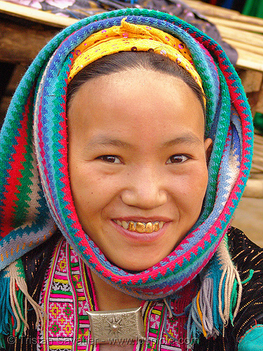 The teeth covered with gold-like metal indicate that this woman is married.