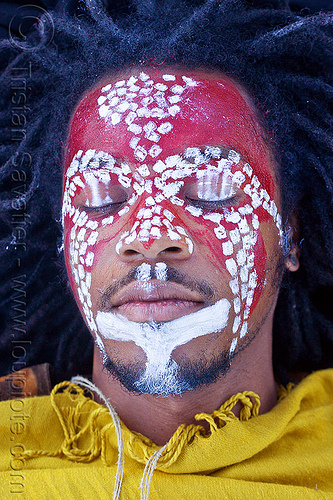 african face paint, african american man, african face paint, black man, dreadlocks, eyes closed, eyes shut, face painting, facepaint, indigenous culture, jason, laying down, makeup, red, tribal face paint, white dots, yellow tunic