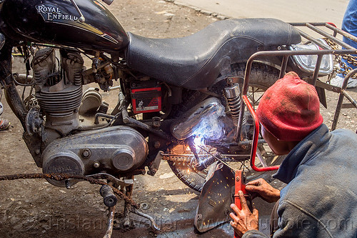 arc welding repair on motorbike rack - royal enfield bullet (india), 350cc, arc welding, fixing, luggage rack, man, mechanic, motorcycle, repairing, royal enfield bullet, sikkim, sparks, thunderbird, welder, worker, working