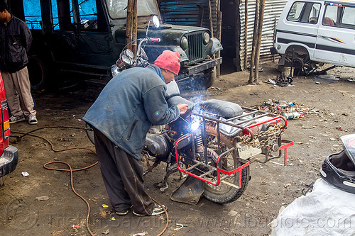 arc welding repair on motorbike rack - royal enfield bullet (india), 350cc, arc welding, fixing, luggage rack, man, mechanic, motorcycle, repairing, royal enfield bullet, sikkim, thunderbird, welder, worker, working