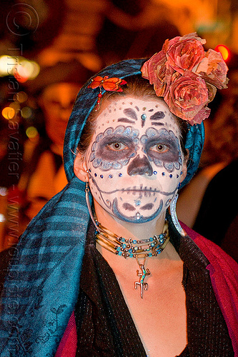 blue sugar skull makeup, blue head cover, blue necklace, day of the dead, dia de los muertos, dry flowers headdress, face painting, facepaint, flower headdress, gecko necklace, halloween, headcover, lizard necklace, night, orange dragonfly jewelry, orange flowers, sugar skull makeup, woman