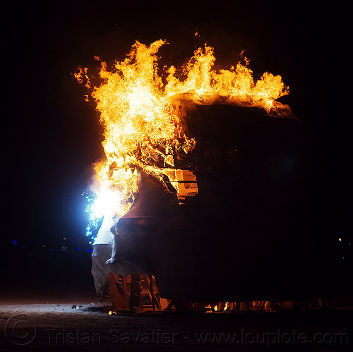 burning man - giant baby head sculpture on fire, art installation, baby head, burning man at night, child head, fire, psychokinetic child, sculpture