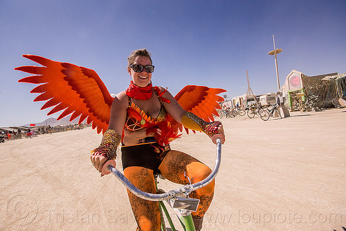 burning man - woman with orange wings, bicycle, leg tattoo, orange, riding, sunglasses, woman