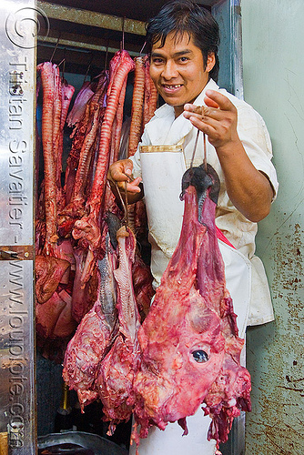 butcher holding beef head, argentina, beef, butcher, cow head, man, meat market, meat shop, mercado central, noroeste argentino, raw meat, salta