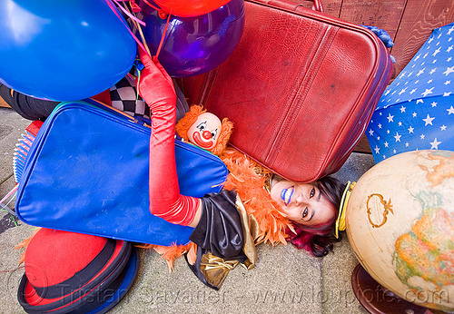 clown act - mumu circus performer, blue lipstick, bowler hat, circus artist, clown, feather boa, globe, luggage, party balloons, performer, props, suitcases, woman