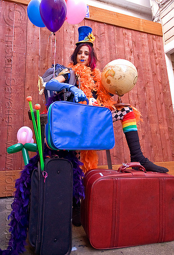 clown act - mumu circus performer, blue lipstick, circus artist, clown hat, cocktail hat, feather boa, globe, luggage, party balloons, performer, props, suitcases, woman