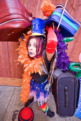 clown act - mumu circus performer, blue lipstick, bowler hat, circus artist, clown hat, cocktail hat, feather boa, globe, luggage, party balloons, performer, props, suitcases, woman