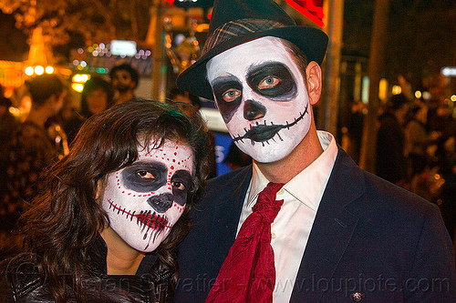 couple with skull makeup, day of the dead, dia de los muertos, face painting, facepaint, halloween, hat, man, night, red spots, red tie, skull makeup, white shirt, woman