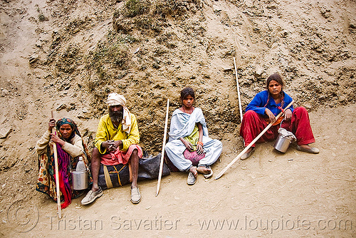 exhausted and dusty family resting on trail - amarnath yatra (pilgrimage) - kashmir, amarnath yatra, hiking canes, hindu pilgrimage, kashmir, mountain trail, mountains, pilgrims, resting, walking sticks