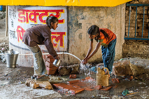 girls washing hands at water hose, bridge pillar, children, daraganj, girls, hindu pilgrimage, hinduism, jerrycan, kids, kumbh mela, little girl, plastic pipe, plastic piping, washing, water hose, water pipe