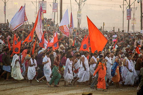 hindu guru and and his ashram members running toward the sangam for holy bath - kumbh mela (india), crowd, dawn, flags, hindu pilgrimage, hinduism, kumbh maha snan, kumbh mela, mauni amavasya, running, triveni sangam, walking