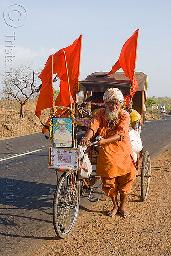 hindu pilgrim on cycle rickshaw (india), amarnath yatra, bare feet, barefoot, bhagwa, cycle rickshaw, headwear, hindu man, hindu pilgrimage, old man, pilgrim, red flags, road, saffron color, trike, walking
