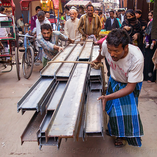 i-beam steel rails rolled on cart in street (india), construction, crowd, delhi, i-beams, men, rope, roped, steel beams, wallahs, workers