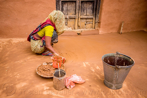 indian woman making earthen floor in house, adobe floor, clay, construction, earthen floor, house, indian woman, khoaja phool, metal bucket, mud, spreading, village, working, खोअजा फूल