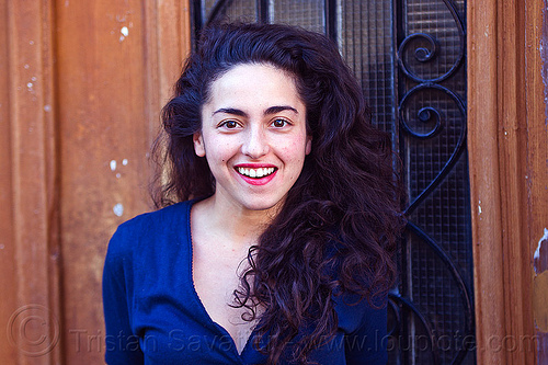 italian girl smiling, brunette, curly hair, dilve, door window, house door, ironwork, italian woman, long hair, red lipstick