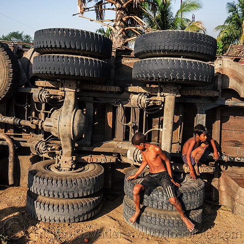 kids playing on overturned truck (india), boys, children, crash, dead axle, differential, kids, lorry accident, overturned truck, playing, road, rollover, sitting, tata motors, traffic accident, truck accident, underbelly, wreck