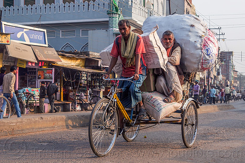 man riding with large sacks of freight on cycle rickshaw (india), bags, cargo, cycle rickshaw, freight, load, men, moving, riding, sacks, transport, transportation, transporting, varanasi