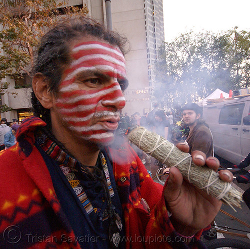 native american burning sage at halloween critical mass (san francisco) - zachary running wolf, american flag, face painting, facepaint, first nations, flag makeup, halloween critical mass, man, native american, sage, salvia, smoke, smoking, us flag, zachary running wolf