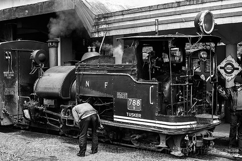 operator inspecting the rods of a steam locomotive at the darjeeling train station (india), 788 tusker, darjeeling himalayan railway, darjeeling toy train, men, narrow gauge, railroad, smoke, smoking, steam engine, steam locomotive, steam train engine, train car, train station, worker, working